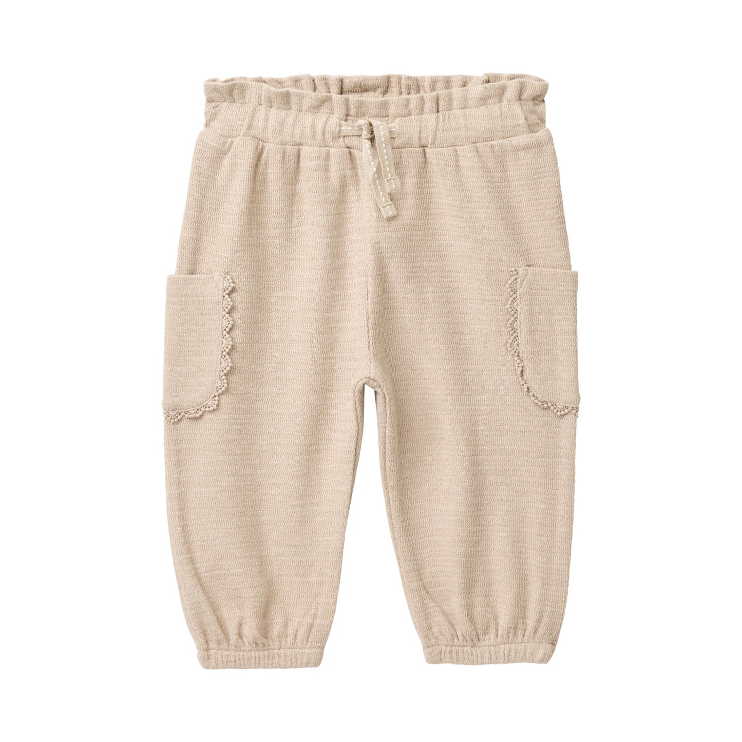 Sandfärgade mjukisbyxor för baby i ekologisk bomull med spetskant runt fickorna, från People Wear Organic